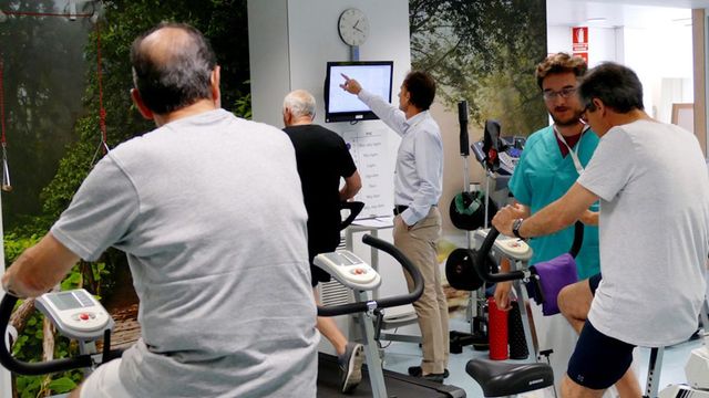 Un médico controla a varios hombres mientras hacen deporte: la actividad física mejora la calidad de vida / QUIRÓNSALUD