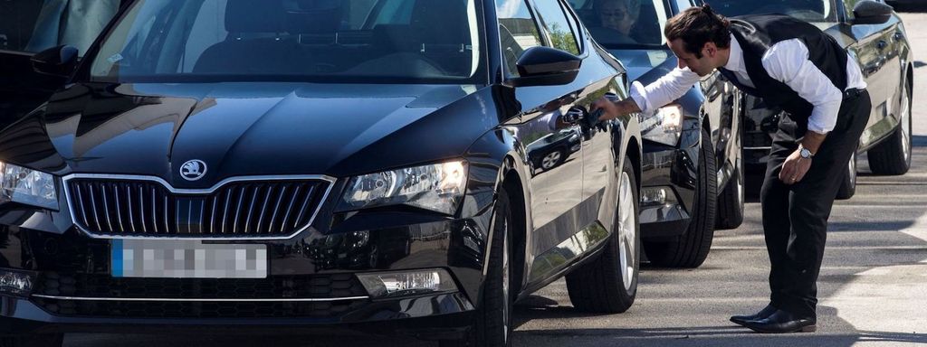 Un cotxe de VTC estacionat i el seu xofer en un carrer de Barcelona / EFE