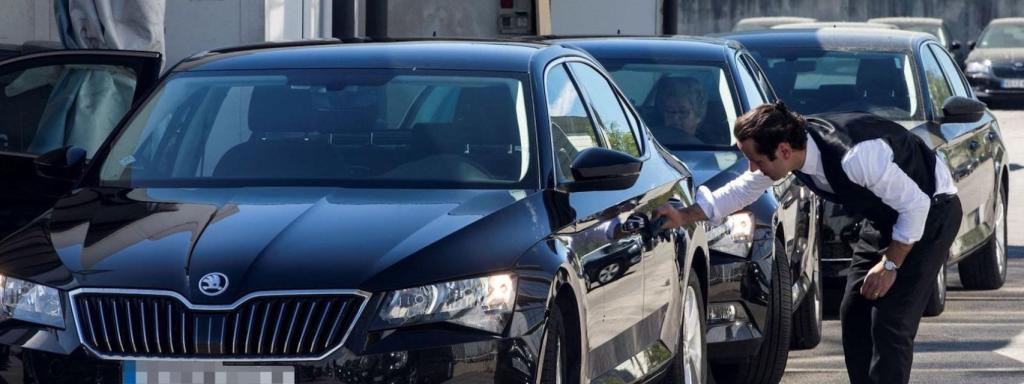 Un coche de VTC estacionado y su chófer en una calle de Barcelona / EFE