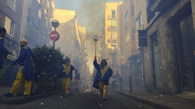 Un 'diable' salta mientras sostiene su antorcha este lunes en la Vila de Gràcia