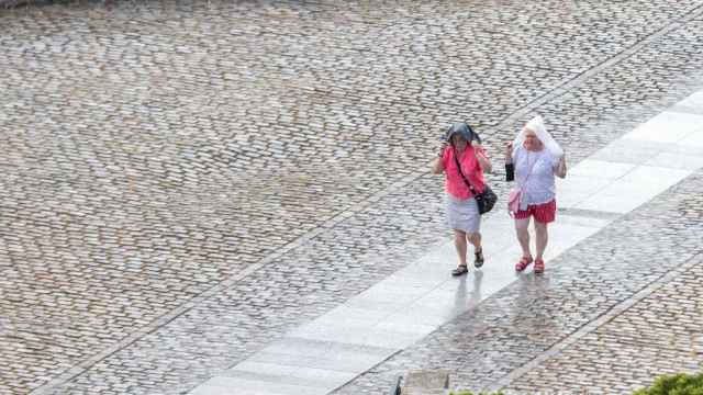 Dos mujeres se protegen de una lluvia de verano