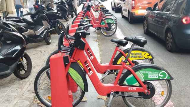 Dos bicis del Bicing con publicidad, una con un anuncio de Bitter Kas y otra con uno de Decathlon / METRÓPOLI - JORDI SUBIRANA