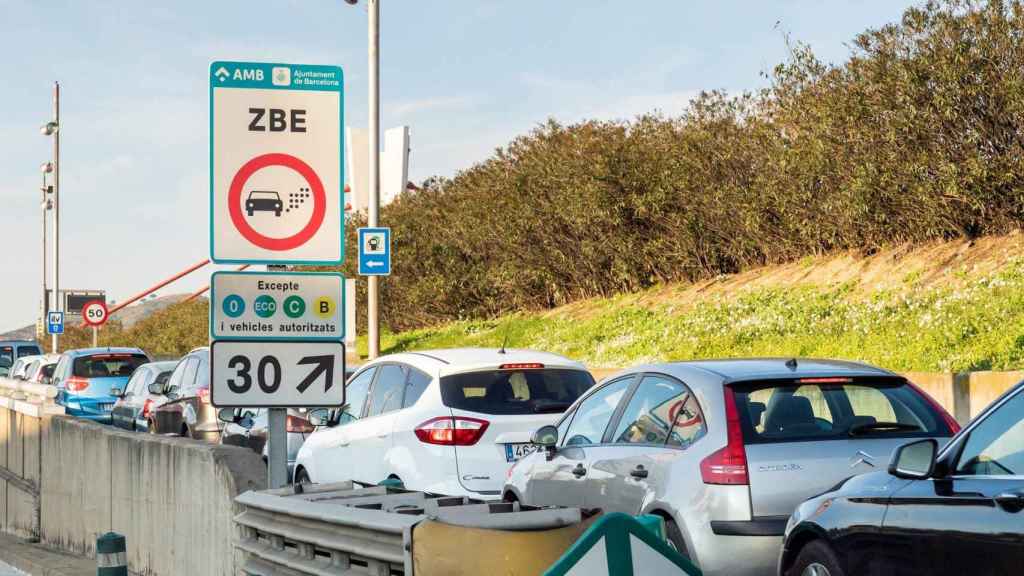 Trànsit al costat d'un cartell de la Zona de Baixes Emissions (ZBE)