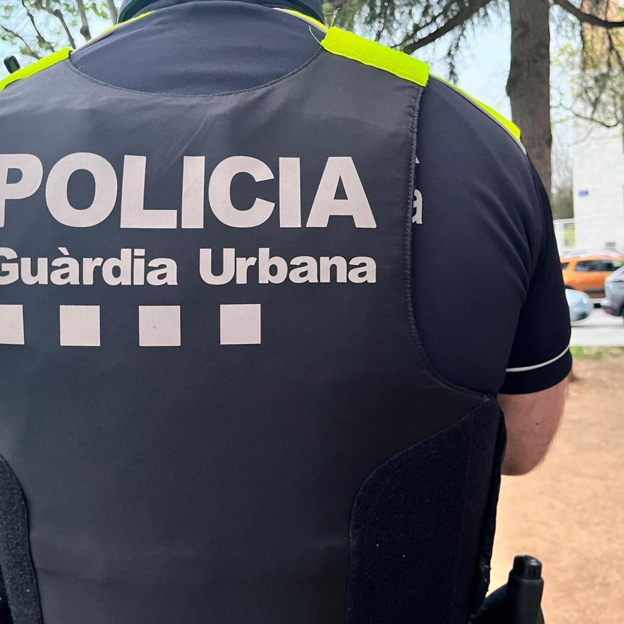 Un agent de la Guàrdia Urbana de Badalona mostrant l'esquena