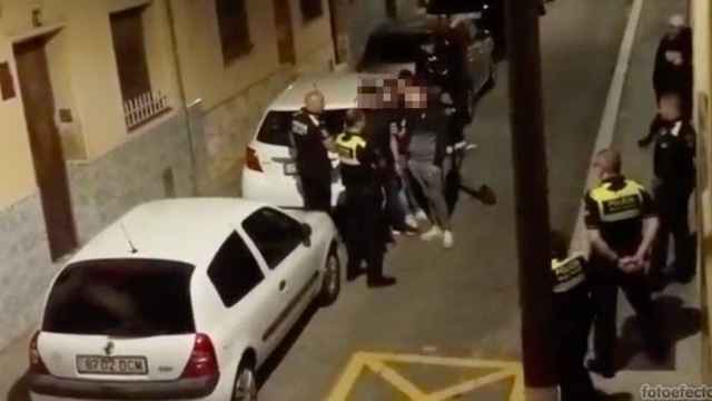El grupo de menores con la Policía Local a las puertas del bloque okupado / CEDIDA