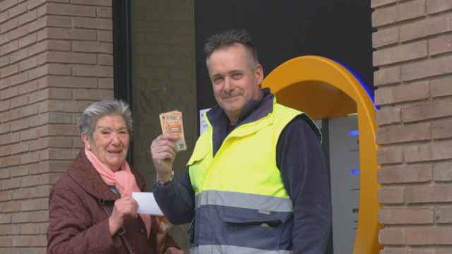 Encarna, una vecina del barrio de Pedralbes, junto a su hijo, sacan dinero del cajero recuperado / BETEVÉ