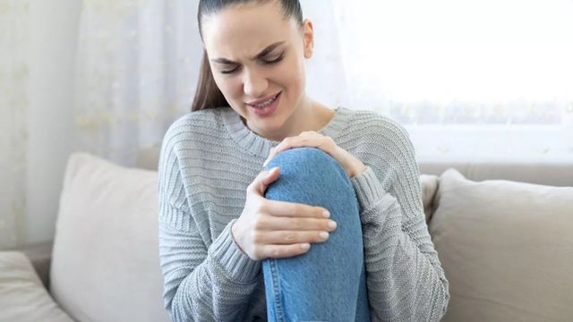 Una mujer se queja del dolor en una rodilla provocado por una tendinitis / QUIRÓNSALUD