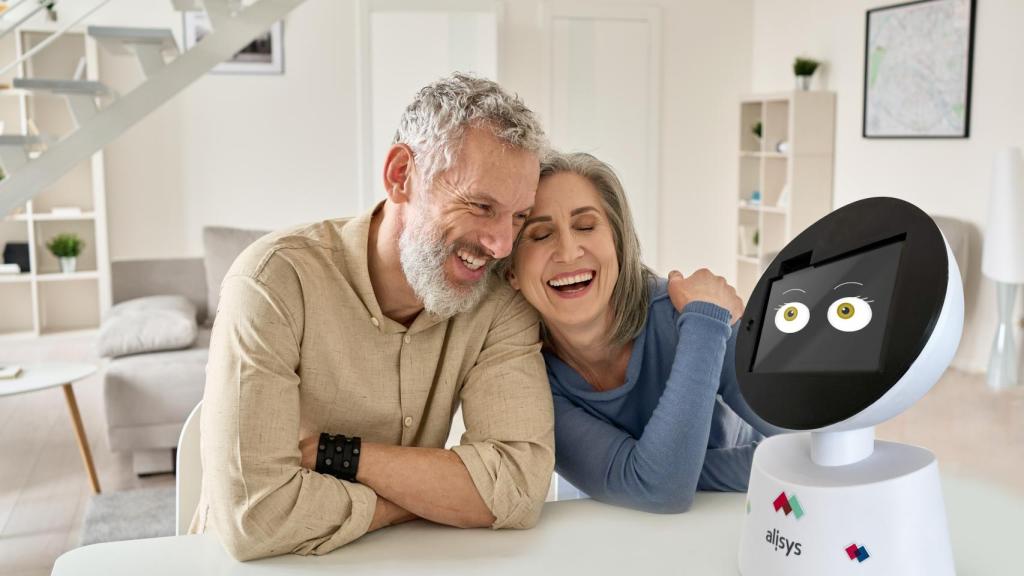 Una pareja de mayores interactúa con el robot sociosanitario Alisys