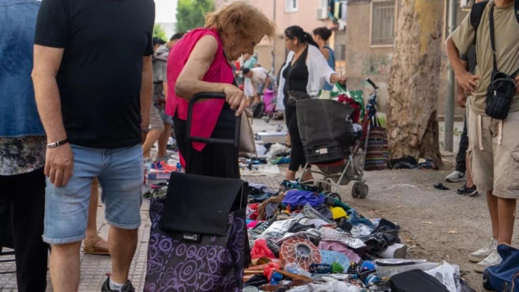 Una dona contempla la mercaderia exposada al mercadillo de la miseria de Badalona / GALA ESPÍN