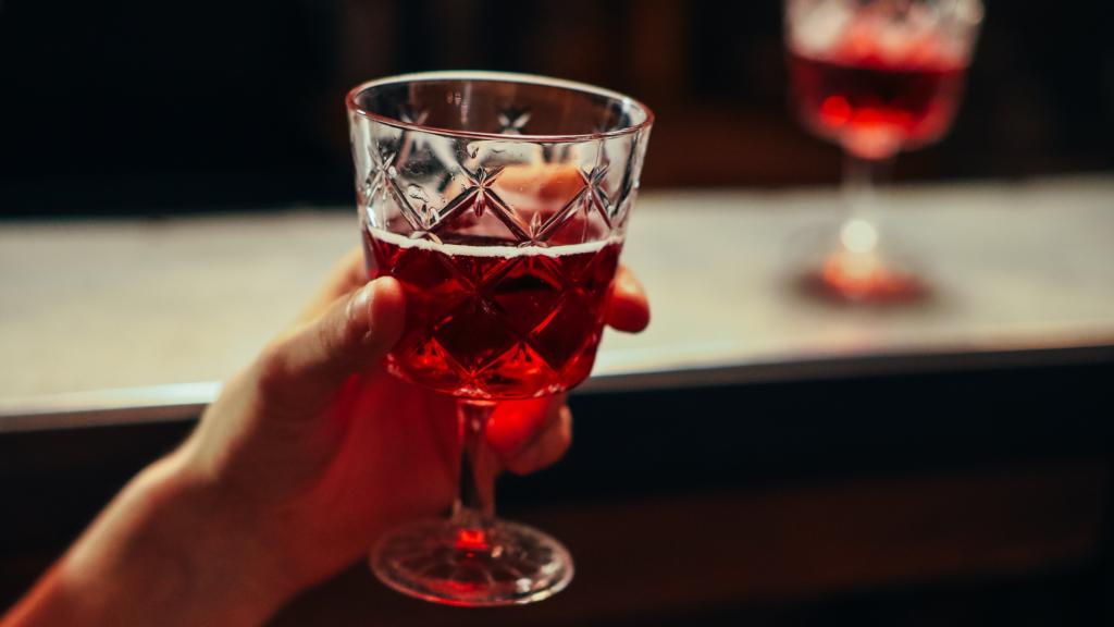 Un hombre sostiene una copa de alcohol