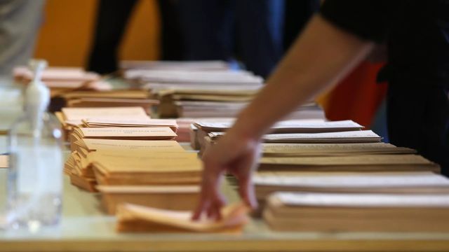 Una persona coge un sobre para votar / Cézaro De Luca - EP