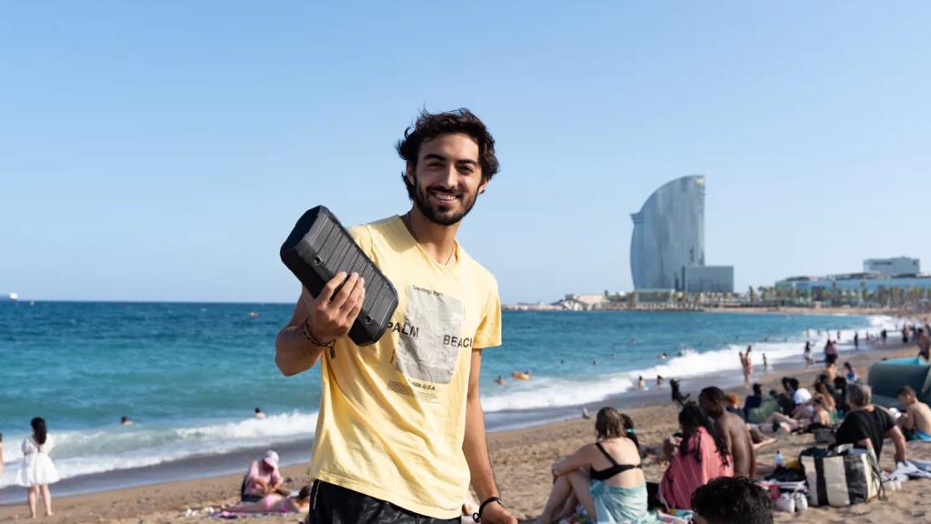 Un banyista a la platja de la Barceloneta amb un altaveu
