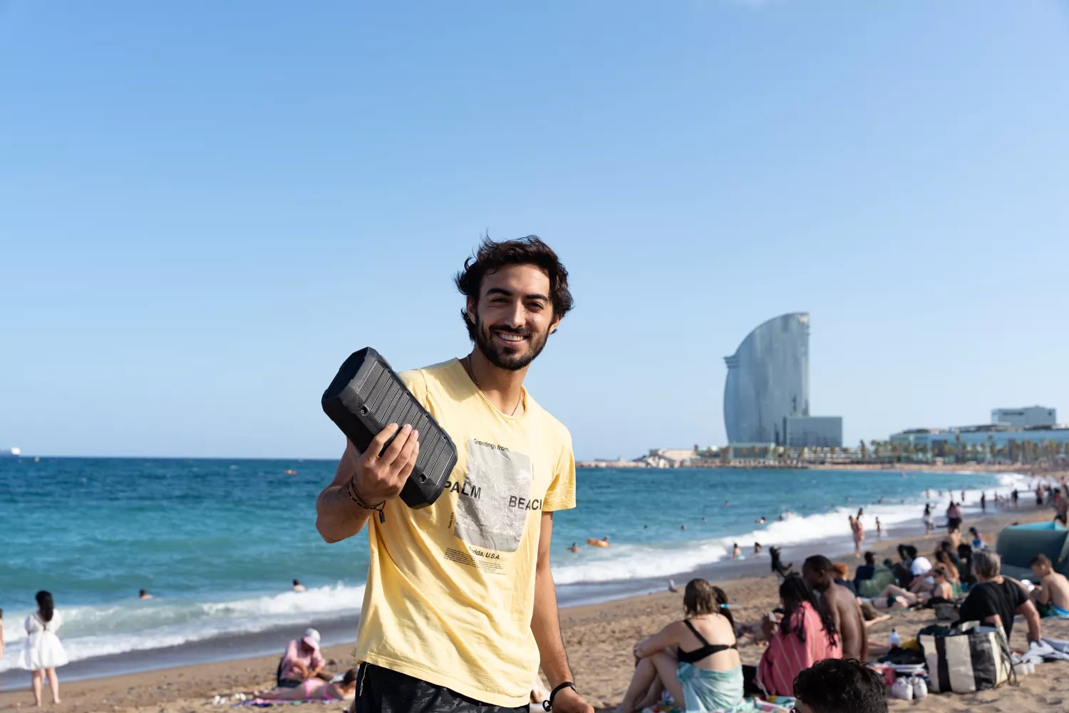 Un bañista de la playa de La Barceloneta con un altavoz / LUIS MIGUEL AÑÓN