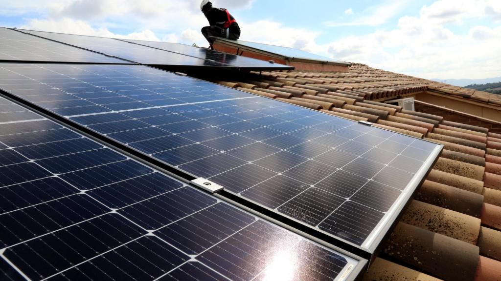 Imagen de un instalador de placas solares en un tejado