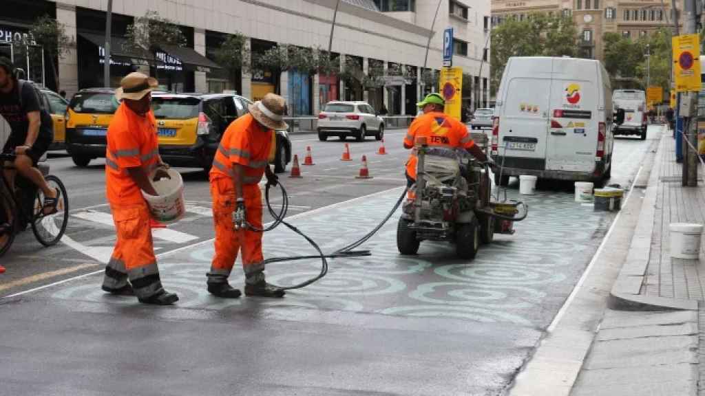 Operarios borran la pintura correspondiente al urbanismo táctico de la calle de Pelai
