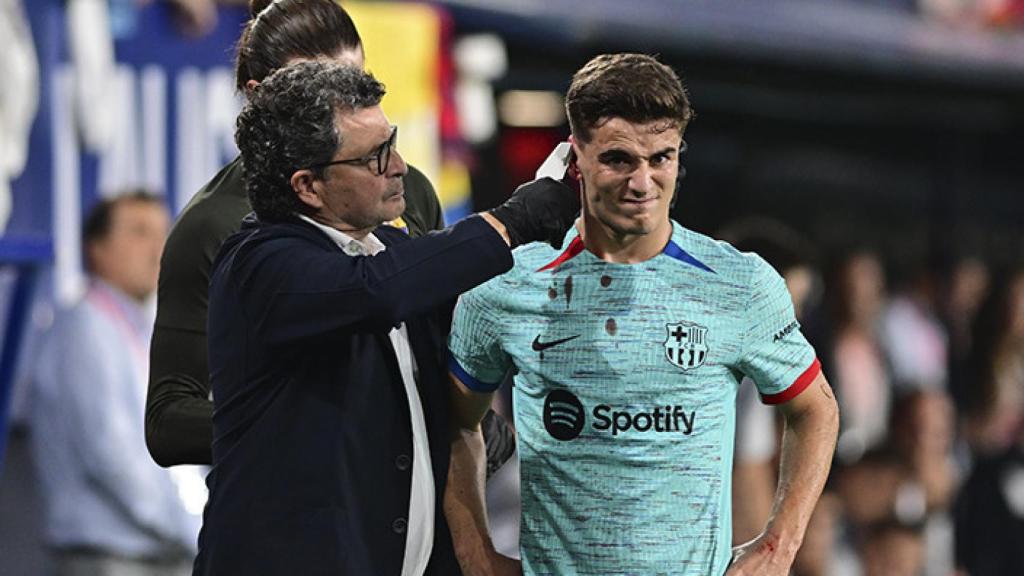 Gavi, atendido por Ricard Pruna, tras sufrir un duro golpe en la oreja derecha