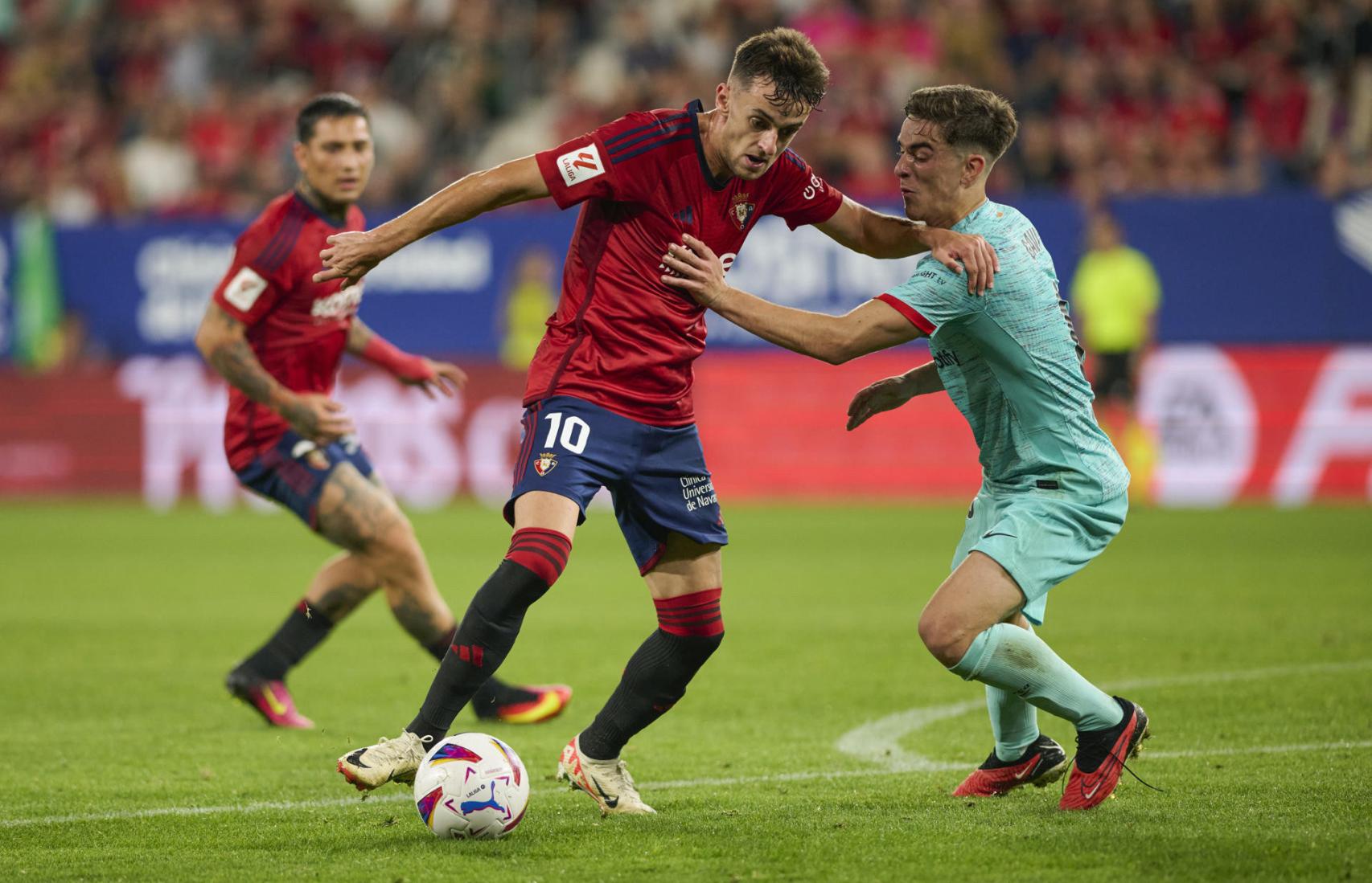 Gavi, luchando por un balón con Aimar Oroz en El Sadar / EFE