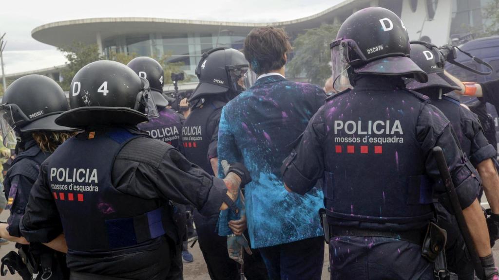 Mossos d'Esquadra ayudan a entrar a la feria The District de Barcelona a uno de los asistentes atacados por los activistas provivienda