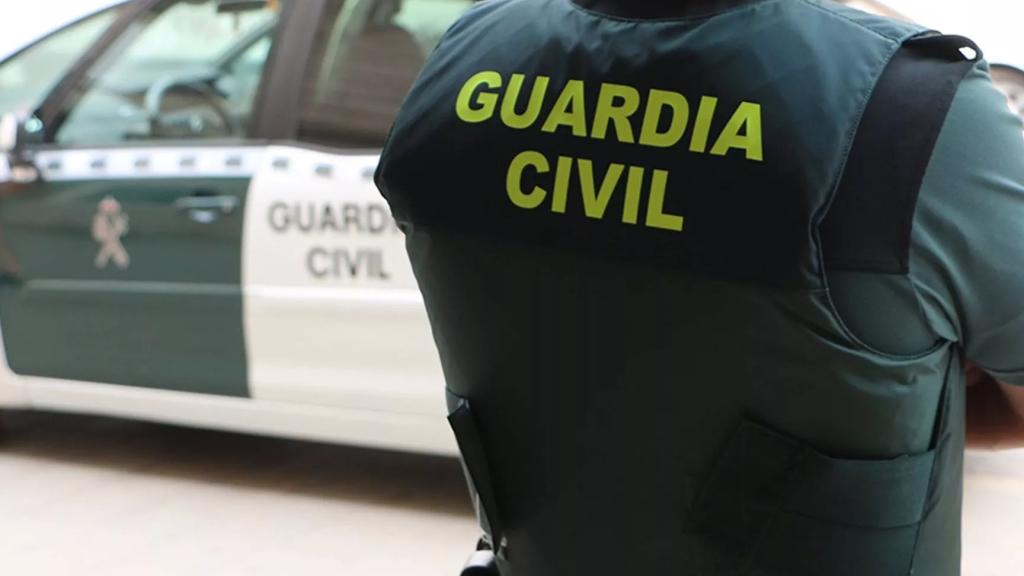 Un agent de la Guàrdia Civil, d'esquena, al costat d'un vehicle oficial / GUÀRDIA CIVIL