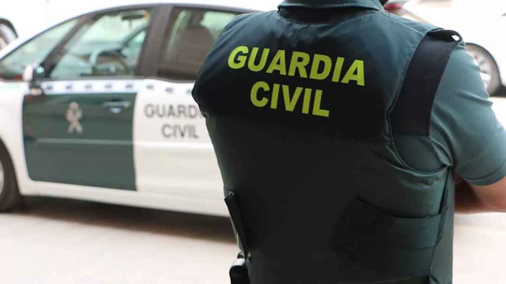 Un agent de la Guàrdia Civil, d'esquena, al costat d'un vehicle oficial / GUÀRDIA CIVIL