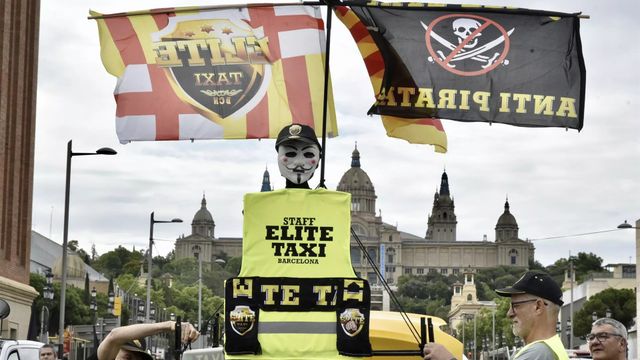 Pancartas y banderas de Élite Taxi durante una marcha lenta en Barcelona / David Oller - EP