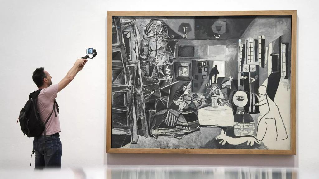 Un hombre fotografía la obra Las Meninas de Pablo Picasso