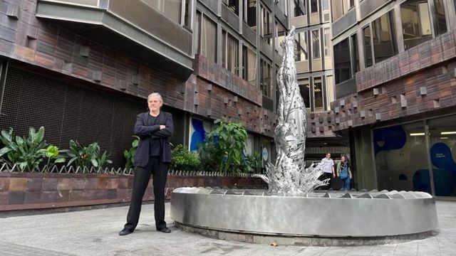 EL artista Jordi Díez posa junto a su obra 'El Saltador', en la entrada de la Torre Urquinaona. - EUROPA PRESS