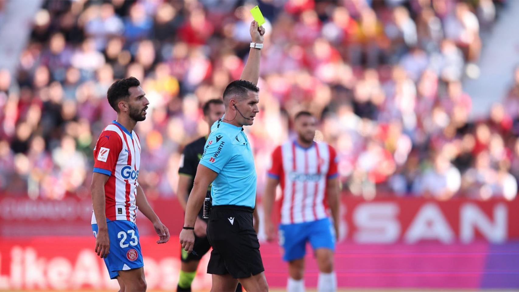 El árbitro Ortiz Arias, mostrando una cartulina amarilla