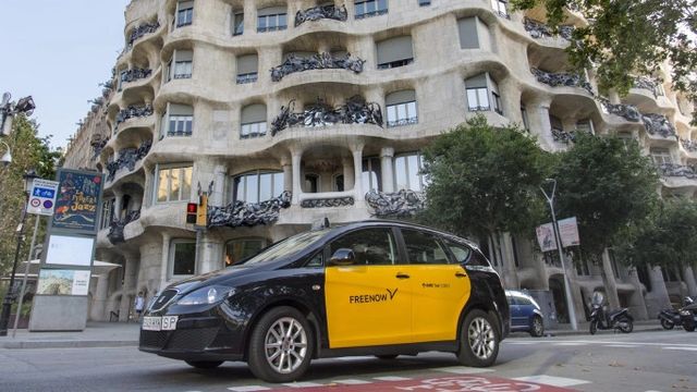 Un taxi circulando frente a la Pedrera en Barcelona