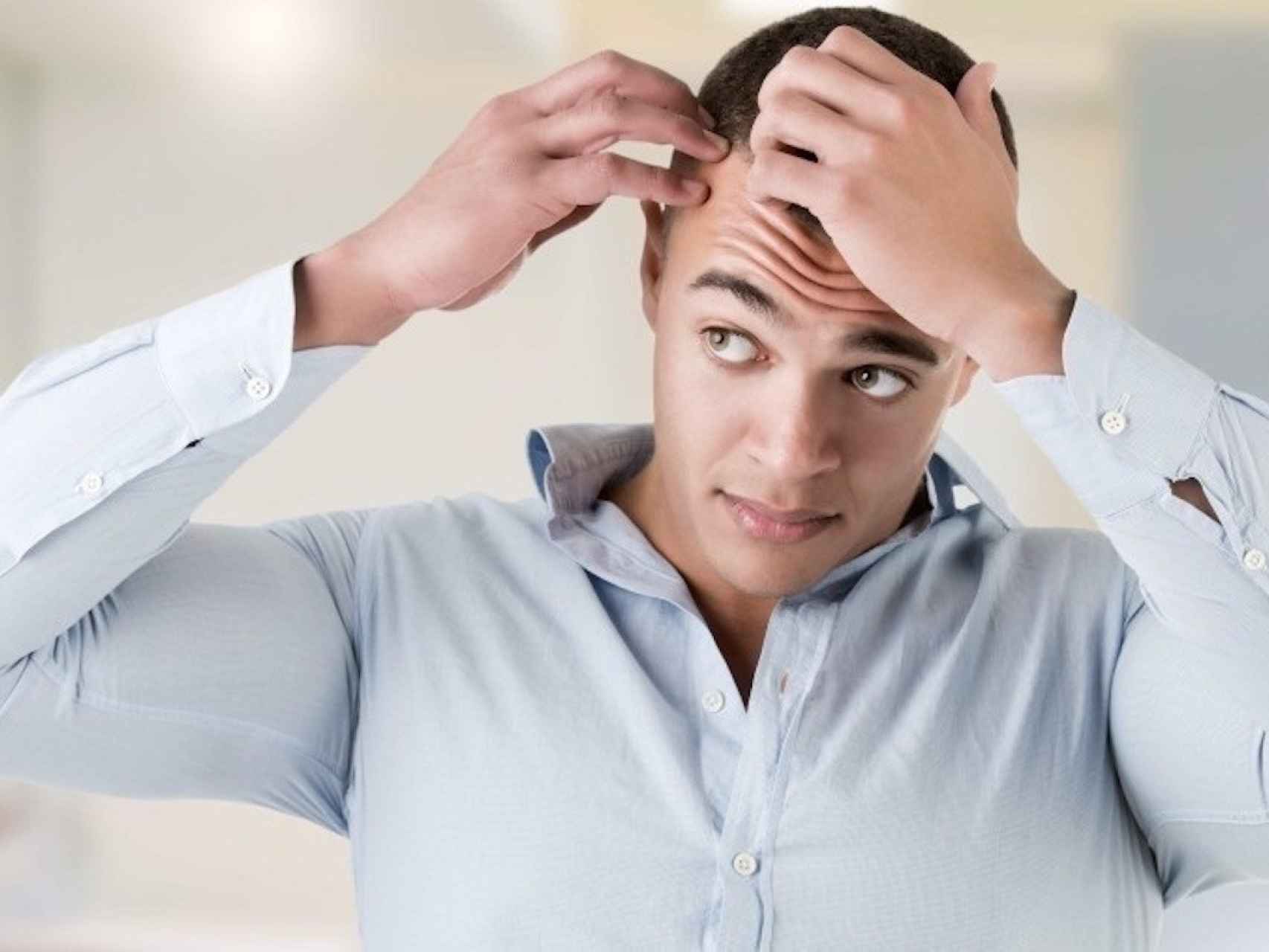 Un hombre revisa su cuero cabelludo