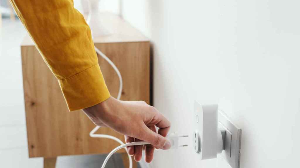 Una persona connectant un endoll en una imatge d'arxiu