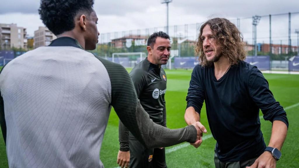 Carles Puyol, saludando a Balde tras saludar a Xavi