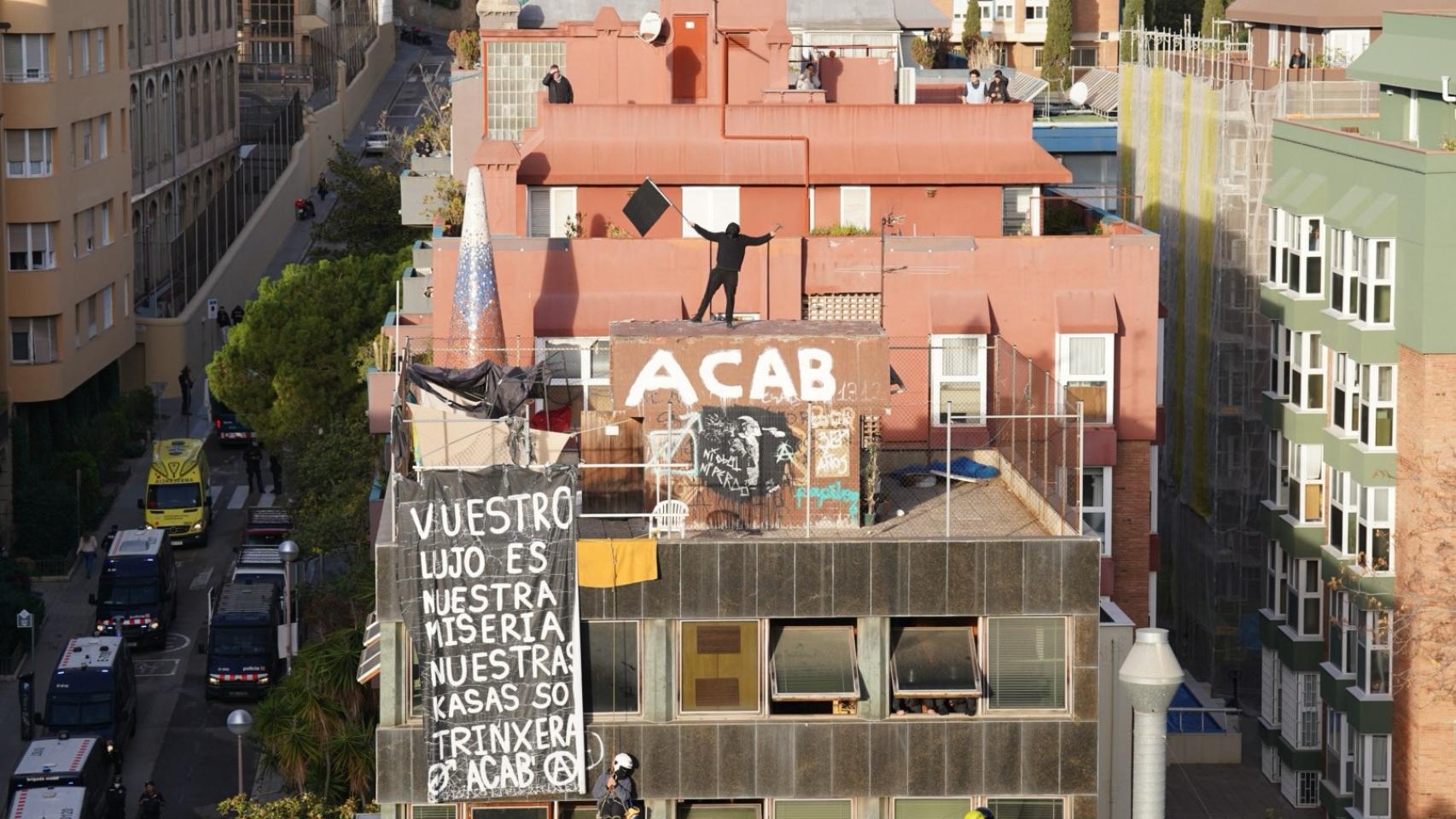 Uno de los okupas en el terrado de el Kubo con una bandera negra