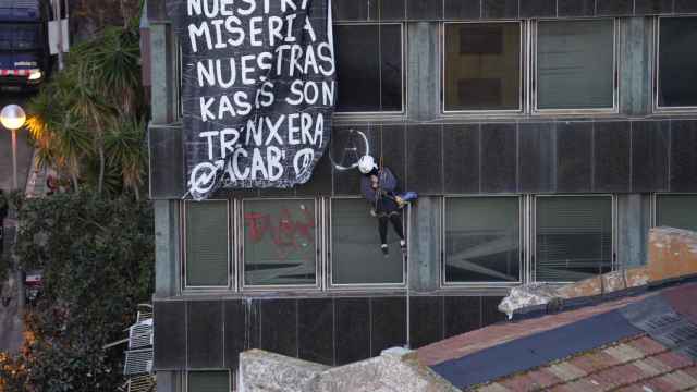 Un okupa colgado del edificio
