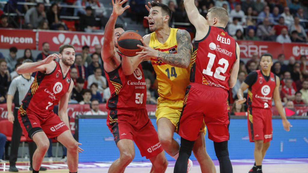 Willy Hernangómez intenta superar a dos jugadores del Zaragoza