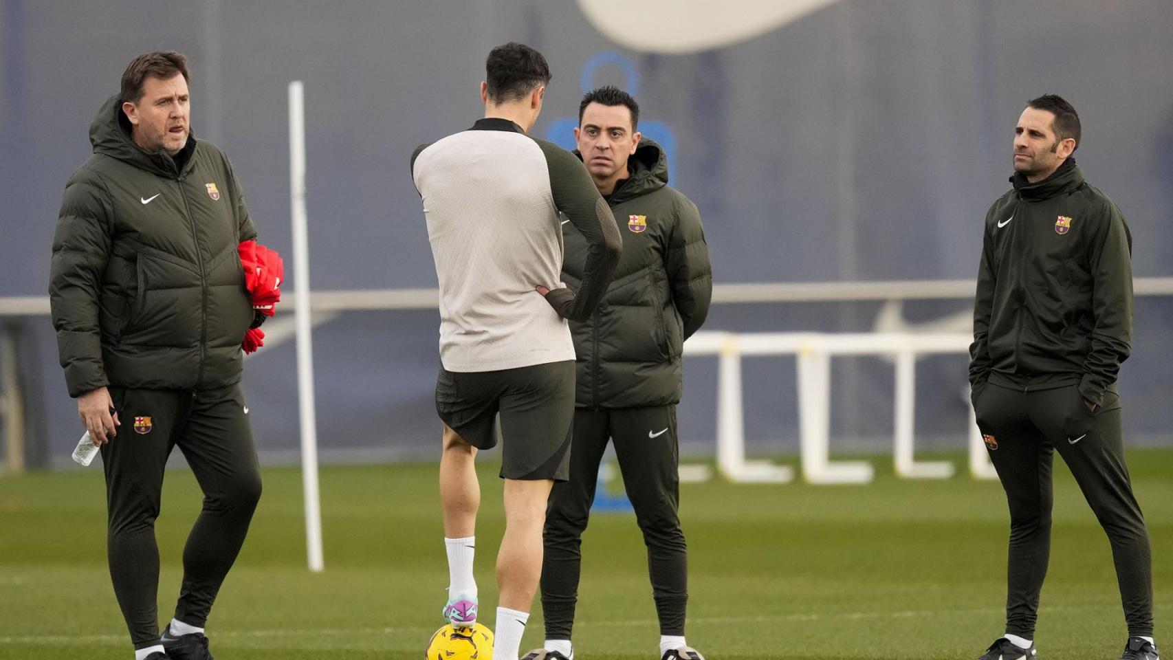 Xavi mantiene una charla con Lewandowski rodeado por miembros de su staff