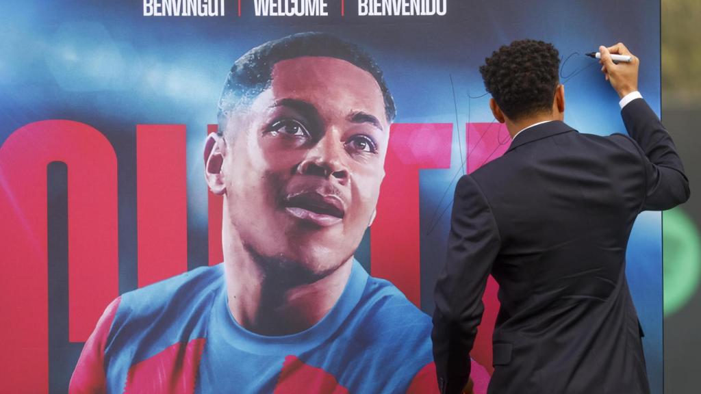 Vitor Roque, firmando su propio poster en la presentación