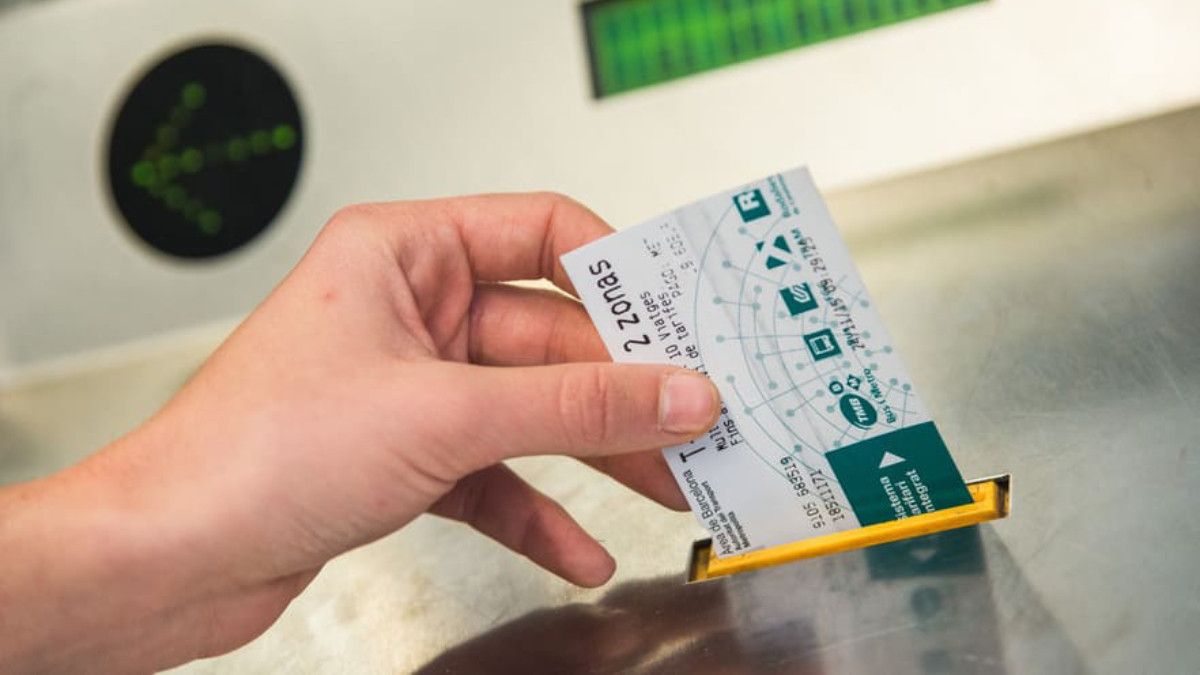 Un usuario del metro de Barcelona validando un billete de cartón en las máquinas