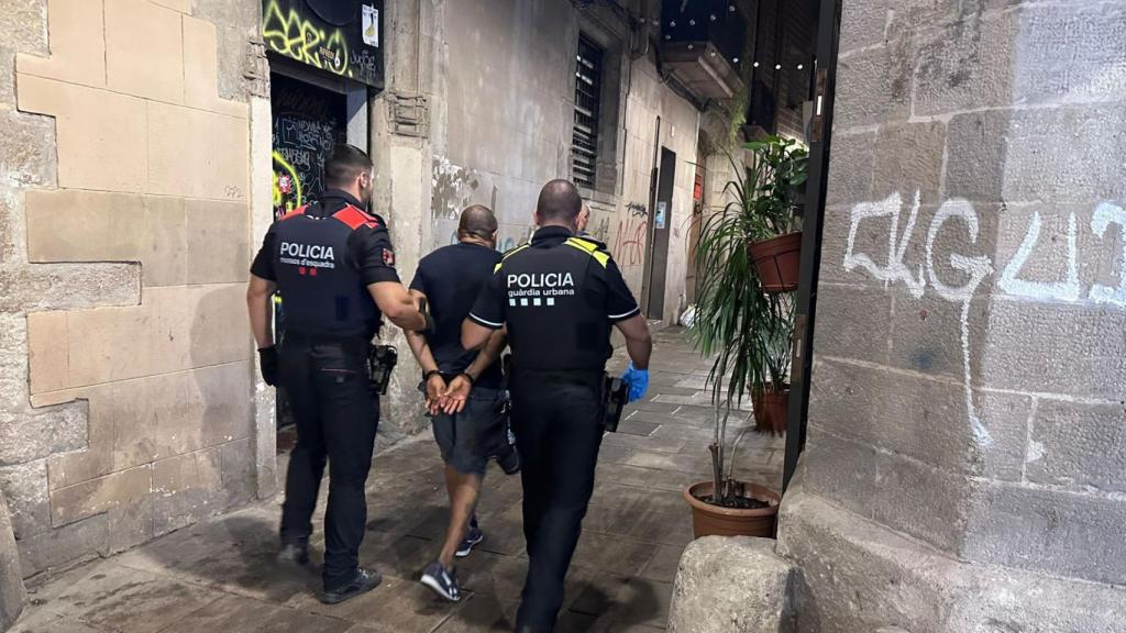 Un agente de Mossos, con uno de la Urbana en una operación contra los narcopisos