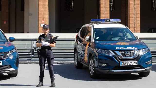 Una agente de la Policía Nacional junto a una comisaría