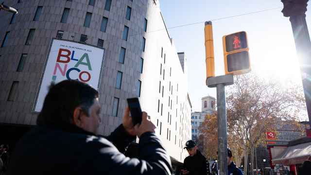 Un barcelonés haciendo una foto al semáforo regulado por Mortadelo y Filemón de plaza Catalunya