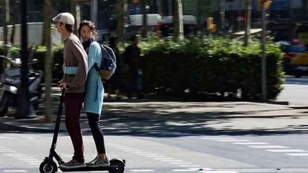 Dues persones circulen en un patinet a Barcelona