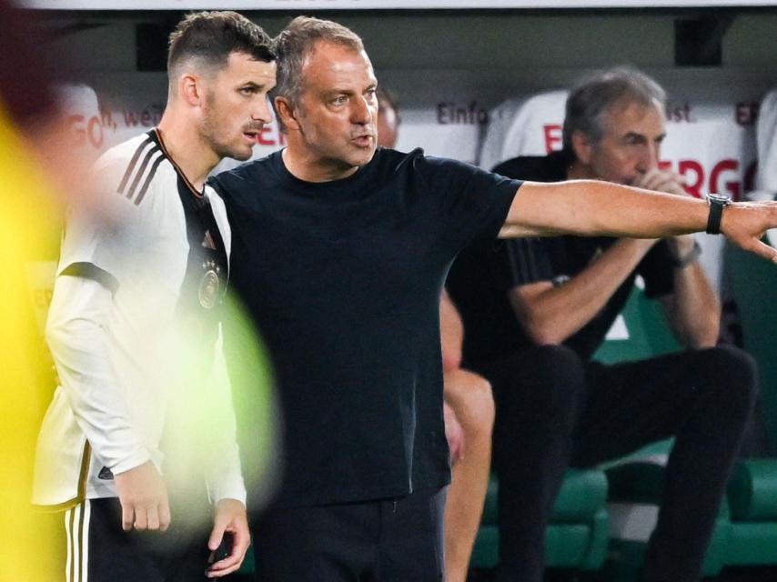 Hansi Flick da instrucciones a un jugador alemán