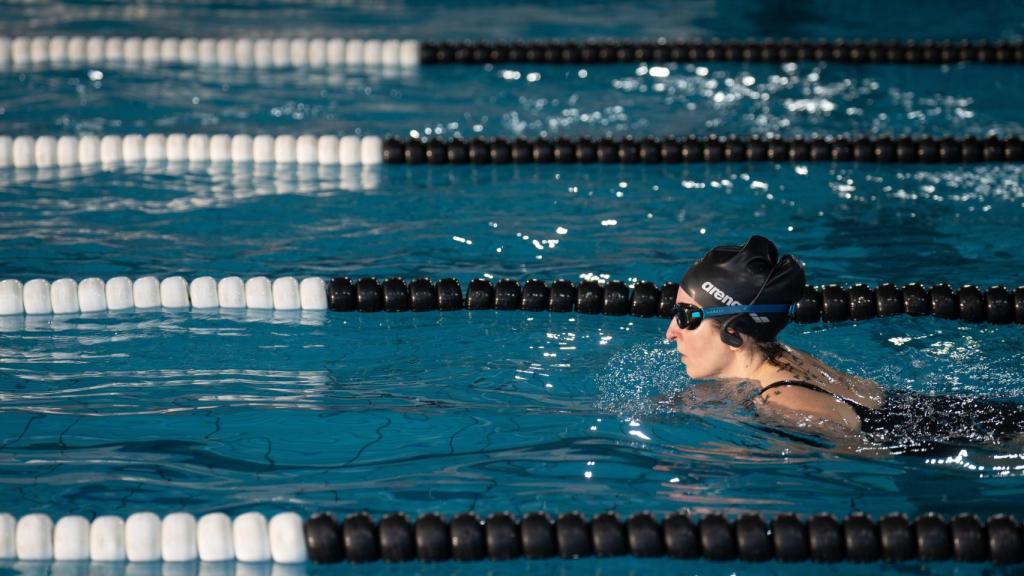 Una persona nada en una piscina de un centro deportivo