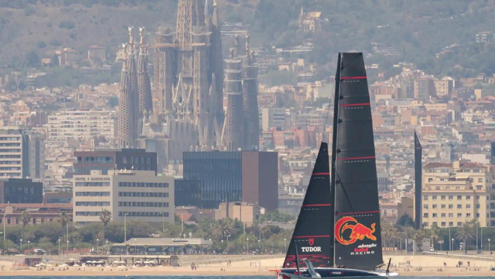 Imagen de un monocasco de la Copa América de vela con la Sagrada Familia de fondo