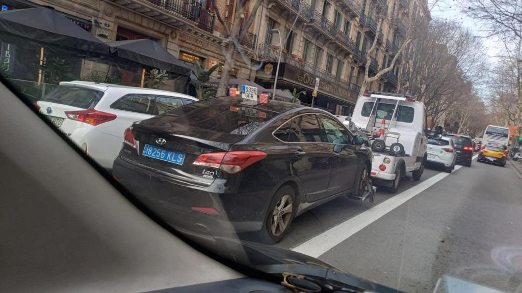 Una grúa traslada un coche de VTC al depósito municipal