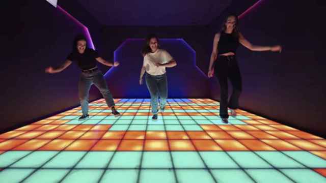 Tres participantes se encuentran en la sala del mosaico que recrea un tetris gigante