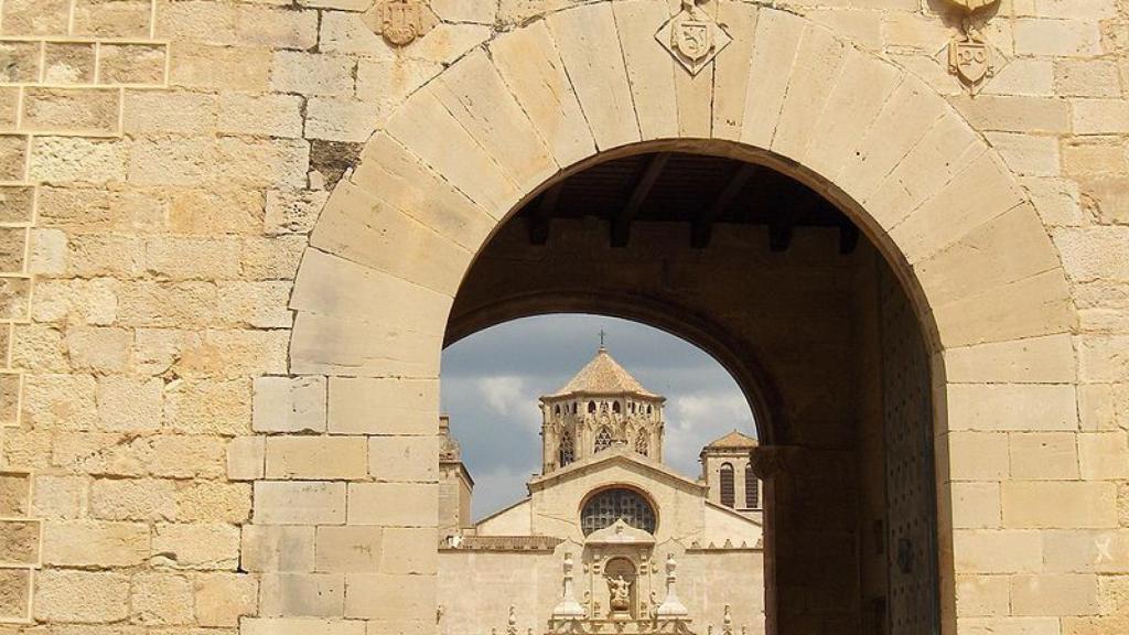 Puerta dorada de Poblet y al fondo la puerta barroca de la iglesia
