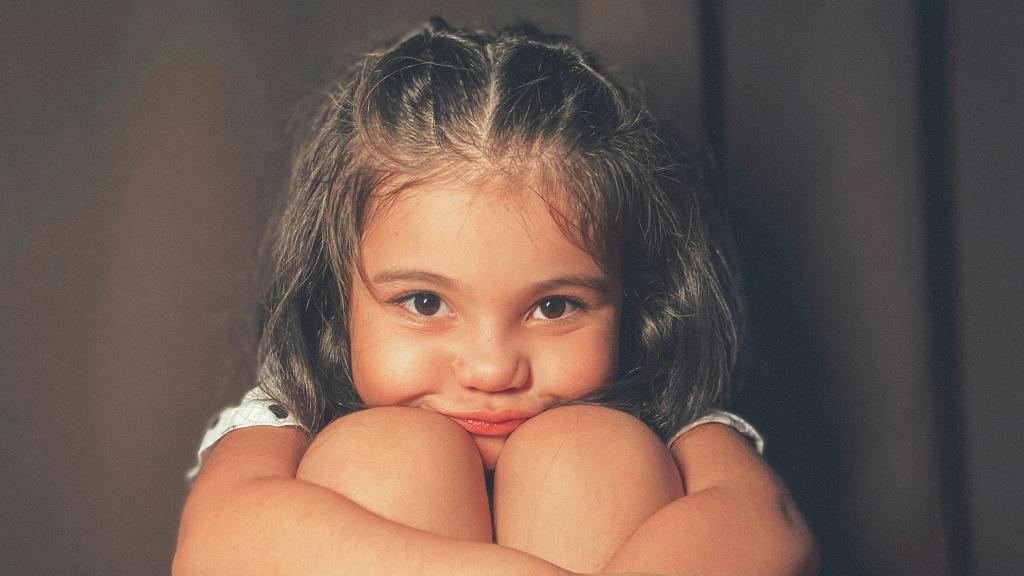 Niña abrazando sus piernas