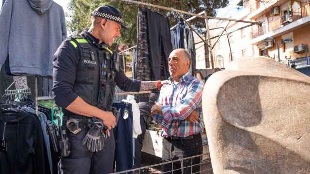 Uno de los agentes de la Policía Local de Santa Coloma con un paradista del mercadillo de Fondo